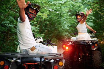 In the forest. Man and woman are on ATV outdoors © standret