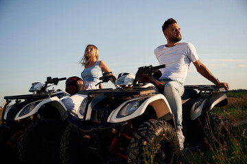 Sitting, taking a break. Man and woman are on ATV outdoors