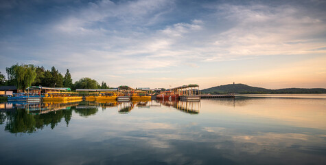 Obraz premium Tranquil Lakeside Evening with Boats