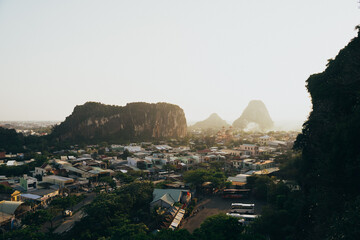 A panoramic view of Da Nang, Vietnam, showcasing mountains, townships, and tranquil landscapes during golden hour