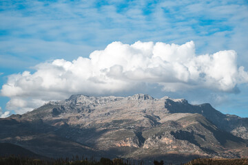 Majestic Atlas Mountains landscape under a bright blue sky with fluffy clouds in rural surroundings during the day