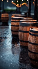 Rain falling on wooden barrels lined up outside a bar at night