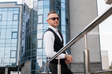 Urban Elegance: A Sophisticated Man in Sunglasses Posing Against Modern Architecture