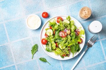 Green vegetable salad with fresh leaves on white plate. Healthy food, diet menu. Top view with space for text.