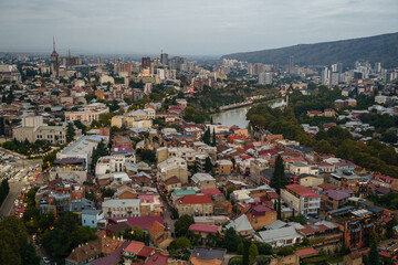 A stunning aerial view of Tbilisis vibrant city at dusk, blending historic and modern architecture