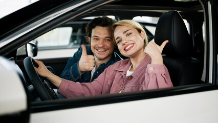 A family couple celebrates their decision to buy a sleek new car at the dealership. Their genuine smiles capture the joy of making an important investment in their family's future and adventures.