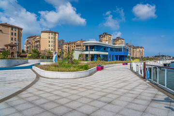 Fototapeta premium Vibrant Waterfront with Modern Architecture and Scenic Blue Sky