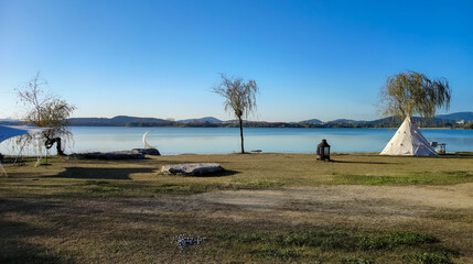 Tranquil Lakeside Scene with Tipi and Solitary Figure