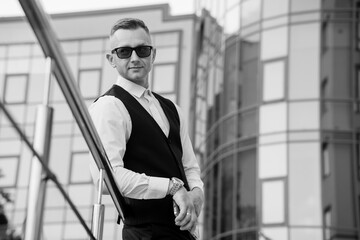 Elegant Man in Sunglasses Posing Confidently Against Modern Architecture