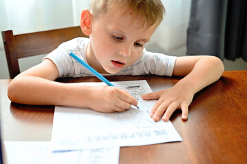 Naklejka premium Boy learning to write letters
