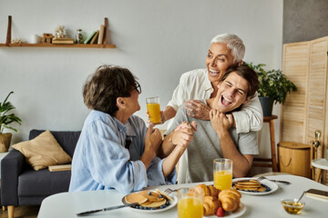A vibrant family breakfast where lesbian parents and their adult son share laughter and delicious food.