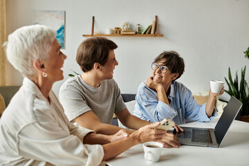 A loving LGBTQ family shares laughter and conversation over coffee in their cozy living room.