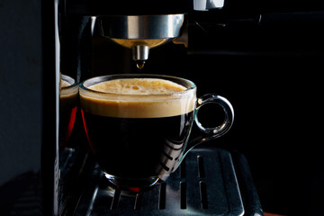 Pouring coffee into the coffee cup close up.Automatic coffee machine.