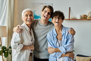 Lesbian parents and their adult son share laughs and joy in a welcoming home setting.