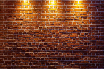 A beautiful old brick wall illuminated by three light sources from above.