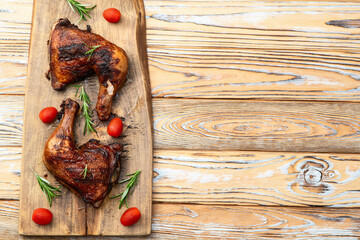 Grilled chicken legs with tomatoes and salad . Top view