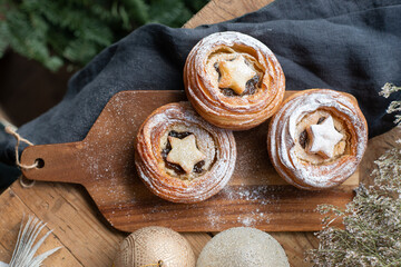 Traditional Christmas mince pies with dried fruits on a decorated table.