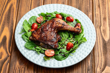 Grilled chicken legs with tomatoes and salad . Top view