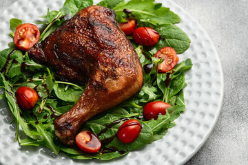 Grilled chicken legs with tomatoes and salad . Top view