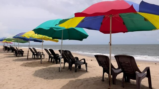 Colorful umbrellas and chairs set up for tourists at Marari Beach at Alappuzha, Kerala, India
