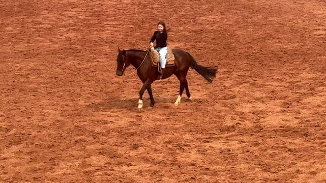 Menina pr&eacute; adolescente anda de cavalo 