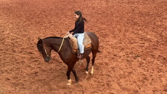 Menina pr&eacute; adolescente anda de cavalo 
