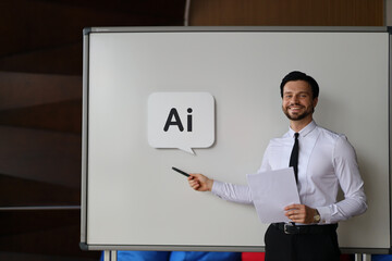 A man is standing in front of a white board with the word AI written on it. He is pointing to the board and smiling