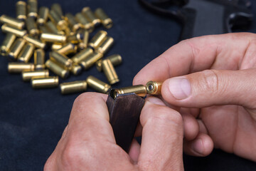 Fototapeta premium Man's hand holding bullet shells on a dark background