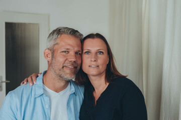 A happy couple is having fun at home while sitting on the floor.