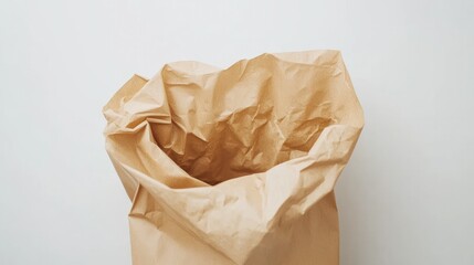 An open paper bag with a crumpled top, placed on a clean white background, perfect for food takeout or eco-friendly packaging visuals.