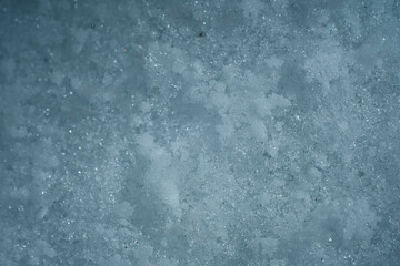 Snowflakes on snow. Christmas and winter background. Natural snowdrift close up photo. Macro picture of snowflakes with crystals in good view.