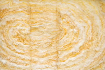 Swirling patterns of yellow insulation material in an unfinished space during daylight hours