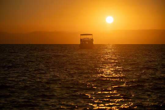ship at sea against the backdrop of sunset
