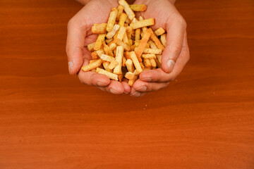 Unhealthy food. Croutons. Unhealthy food for figure, heart, skin, teeth. Fast carbohydrates. Wooden background. Salty snack for beer. Junk food. Fast food. Snack. Cholesterol.