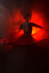 Fototapeta premium Silhouette of a woman in a red skirt dancing Latin in smoke in neon light. Dance concept. Bachata, Latina