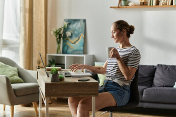 A smiling woman with vitiligo sips coffee while engaging with her laptop.