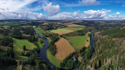 Fototapeta premium Luftbild der malerischen Flussschleife am Petersgrat Blick, die sich durch eine vielfältige Landschaft schlängelt. Die Szene wirkt ruhig und idyllisch. Joditz, Köditz, Oberfranken, Deutschland.