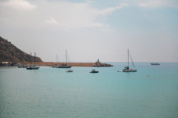 Tranquil seaside harbor with boats and calm waters under a blue sky