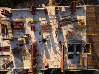 A drone video showcasing a top-down view of a construction site. The image captures the building's foundation, scaffolding, and materials, highlighting the early stages of architectural development