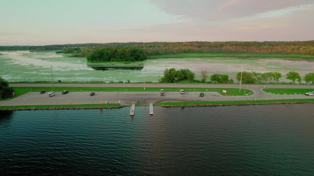Aerial view over the parking lot and water surface of Green Lake Inlet Boat Launch in Ripon, Wisconsin. Recreational access to the lake and the intersection of nature and public amenities.