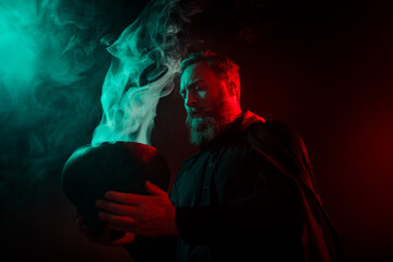 Photo of wizard warlock hold cauldron making poison magic ritual halloween night isolated on dark...