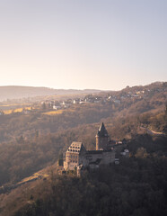 Obraz premium Enchanting Winter Sunrise Over Castle Stahleck Bacharach: A Peaceful Morning by the Rhine