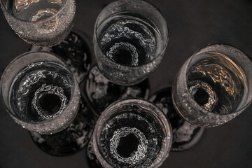 Viking Age Ring. Jewelry ring on the background of a glass for alcohol. Silver ring on a dark background.