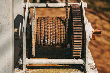 Corrosion. Destruction. Rust old industry steel cable on reel. Aged grunge weathered wire and chain. Metal rope on a spool. Concept of wear and tear. Oxidized colorful textured mechanical components.
