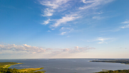 A stunning aerial view of Lake Sniardwy in Poland, showcasing its expansive waters and lush green surroundings under a clear blue sky.