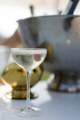 Close-up of a chilled champagne glass with a raspberry