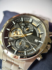 Stylish wristwatch with black dial and gold accents close-up