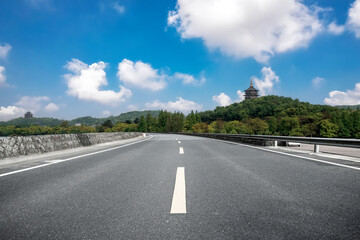 Scenic Highway with Lush Greenery and Blue Sky Ahead