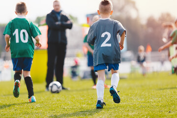 Fototapeta premium Young Soccer Players Competition. Boys Kicking Football Ball. Soccer Youth Teams Play Outdoor Tournament. Soccer Stadium in the Background