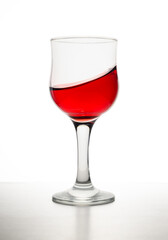 Red wine in glass in front of white background